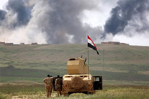soldados iraqíes contemplan el humo de las batallas